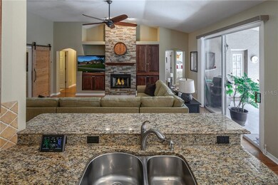The kitchen with granite counters opens to the gre