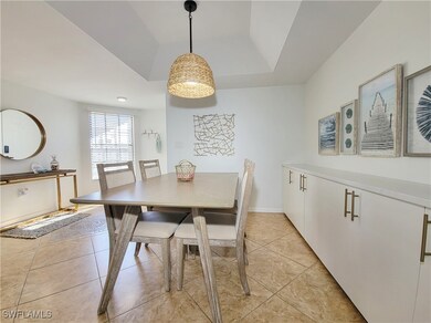 Tiled dining space featuring a tray ceiling