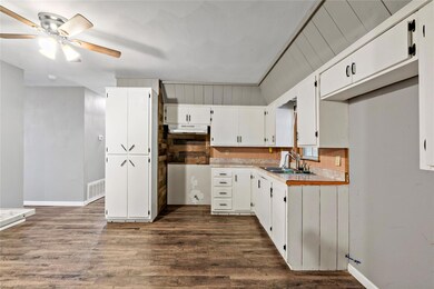 Kitchen with dark hardwood / wood-style floors, si