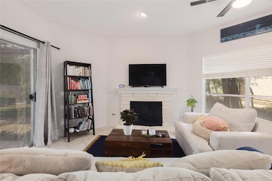Living room with crown molding, ceiling fan, a fi