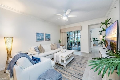 Living room with crown molding, ceiling fan, and l