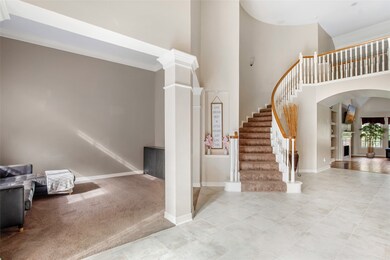 Elegant curving stairway ascends to the home's sec