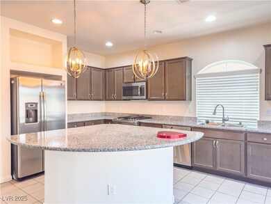 Kitchen with stainless steel appliances, a chandel