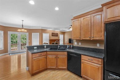 Kitchen with black appliances, recessed lighting, a peninsula, french doors, and decorative light fixtures