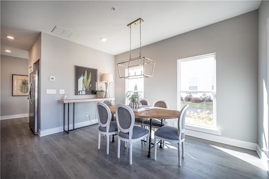 Dining space featuring dark wood-type flooring, baseboards, recessed lighting, and a chandelier