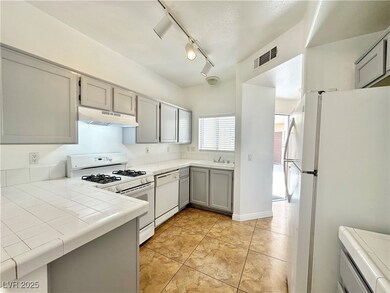 Kitchen featuring under cabinet range hood, white