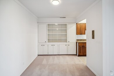 Corridor with ornamental molding and light carpet