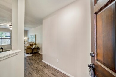 Without further ado, come on in! The beautiful dark stained wood door opens to reveal GORGEOUS dark neutral wood-like floors that flow through the main areas of the home.