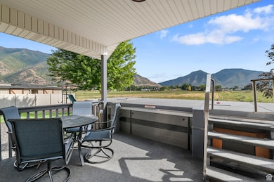 View of patio / terrace featuring a mountain view, a hot tub, and outdoor dining area