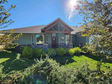 Craftsman-style house with a porch, a front lawn, stone siding, and stucco siding
