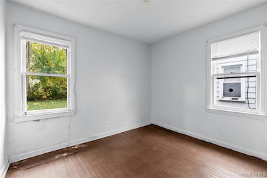 Unfurnished room featuring dark wood-style floors and a textured ceiling
