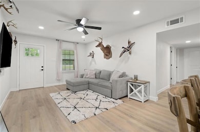 Living area featuring ceiling fan, light wood finished floors, and recessed lighting