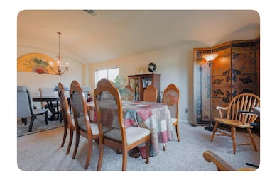 Carpeted dining space featuring an inviting chand