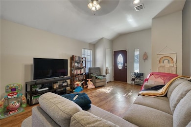Living room with lofted ceiling, ceiling fan, wood