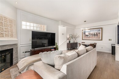 Living area featuring a stone fireplace and wood f