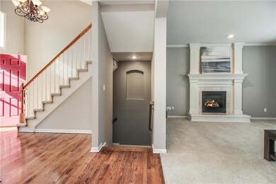 Foyer with grand staircase and iron chandelier.