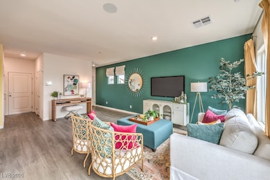 Living area featuring wood finished floors and recessed lighting. Home is representational only; actual home finishes may vary.
