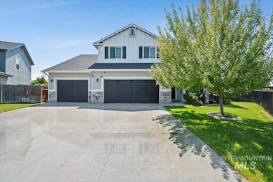 View of front of house featuring stone siding, driveway, board and batten siding, and a garage