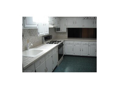 kitchen with stove/oven. pass thru to dining area.