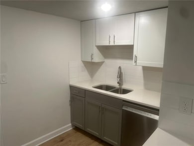 Kitchen with backsplash, light countertops, a sink
