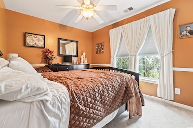 Carpeted bedroom with baseboards and a ceiling fan