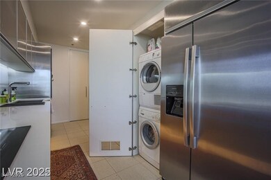 Laundry room with light tile patterned floors, estacked washer and dryer, and recessed lighting