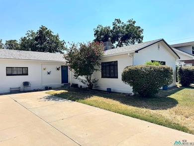View of front of house featuring brick siding, a front lawn, a shingled roof, and concrete driveway