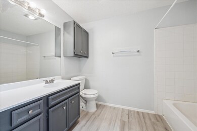 Full bathroom featuring wood finished floors, toi