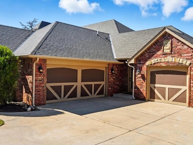 View of front of property featuring concrete driveway, roof with shingles, brick siding, and a garage