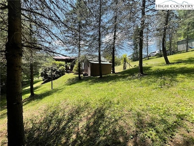 Side yard looking towards the home and outbuilding