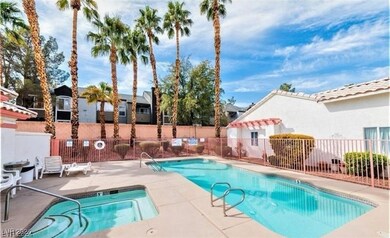 Community pool with a patio area and fence