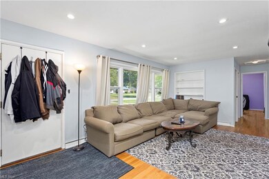 Hardwood floored living room featuring a baseboard