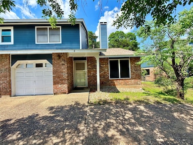 View of front of house with a garage, brick sidin