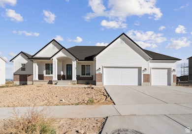 View of front of home featuring a porch, brick siding, driveway, and an attached garage