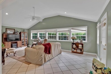 Tiled living room featuring ceiling fan, lofted ce