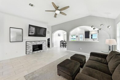 Living room with a ceiling fan, arched walkways, 