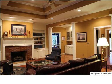 Family Room with gas log fireplace, recessed lighting, columns, hardwood floors, tray ceiling. Also notice the wetbar located between the Family Room and the Kitchen.
