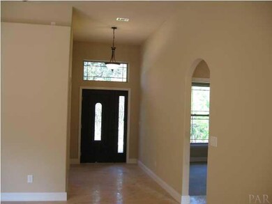 view from living area to foyer and arched entry to guest bedroom wing
