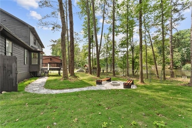View of yard with a custom-built outdoor fire pit with seating area and a brand new deck