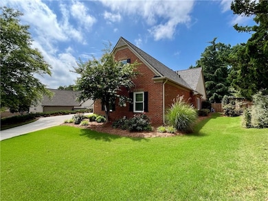 View of side of property featuring brick siding, driveway, and a shingled roof