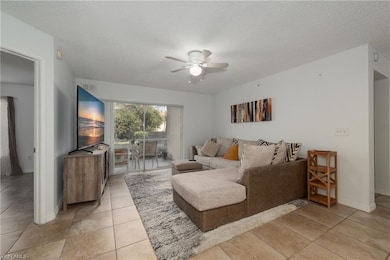 Living room featuring ceiling fan, a textured ceil