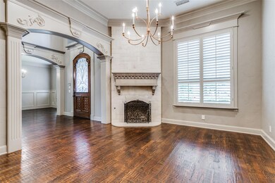 Unfurnished living room with crown molding, dark hardwood / wood-style flooring, a notable chandelier, and a large fireplace