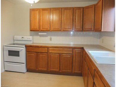 Kitchen has a refrigerator, oven and range.