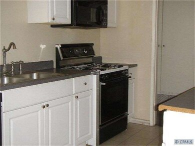 Kitchen with new cabinetry and tile flooring.