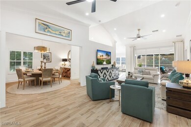 Living room with high vaulted ceiling, crown molding, light wood-style flooring, recessed lighting, and ceiling fan