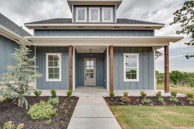 View of exterior entry with board and batten siding and covered porch