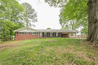 View of front of property with brick siding and a carport