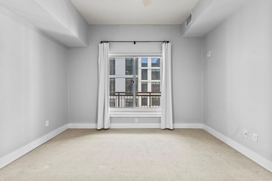 Carpeted spare room featuring visible vents and b