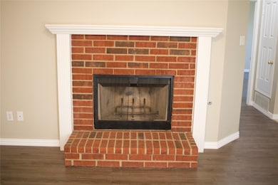 Detailed view of wood finished floors and a brick fireplace