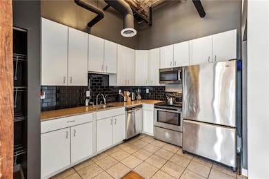 Kitchen featuring backsplash, a towering ceiling, 